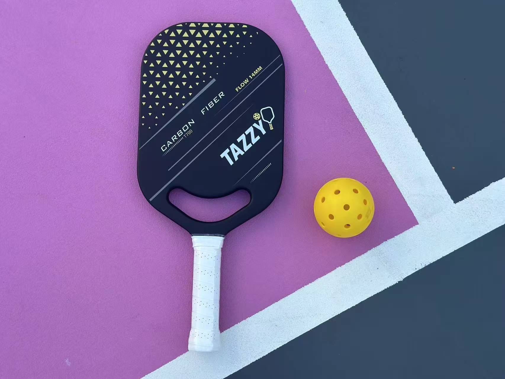 Tazzy Flow 14mm T700 carbon fiber pickleball paddle on court with pickleball